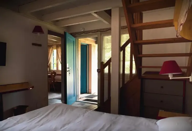 Chambre avec lit double et escalier en bois
